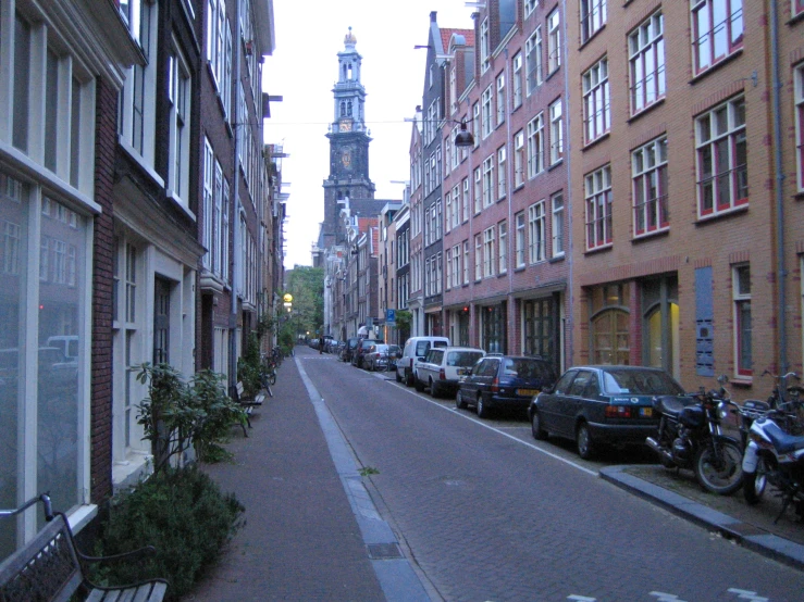 a city street lined with brown buildings and a tower