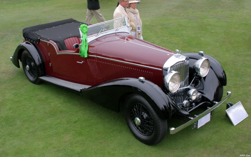 an old car is parked in the grass