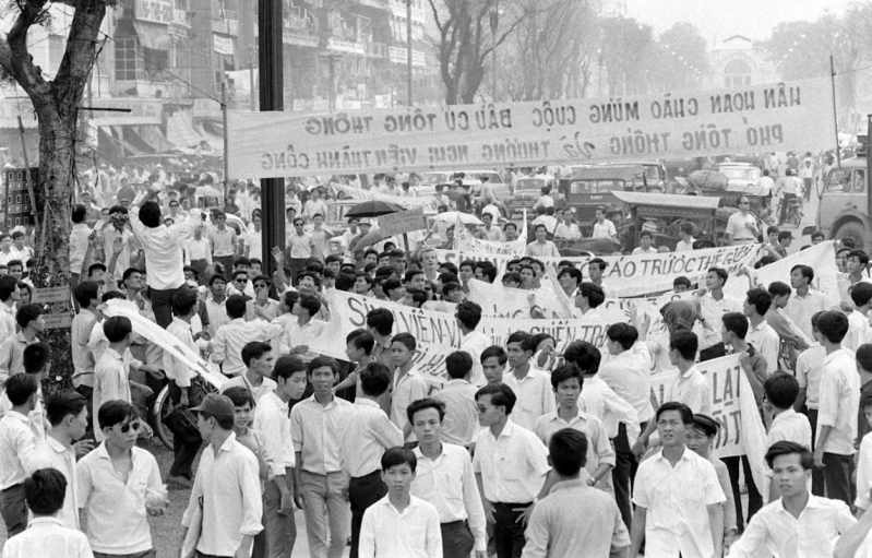 a group of people holding a protest sign in front of buildings