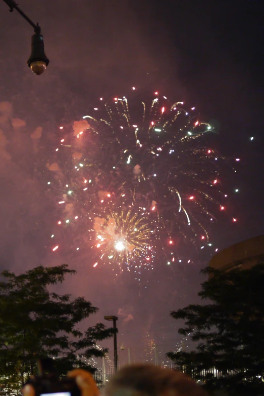 fireworks are glowing off the water and into the sky