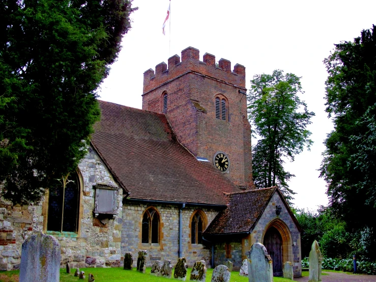 an old fashioned church with a steeple surrounded by tombstones