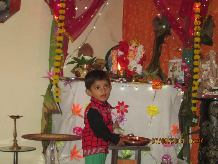 a young child is standing in front of a decorated altar