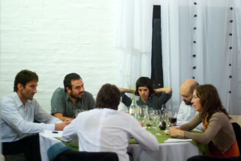 group of people sitting around a table having drinks