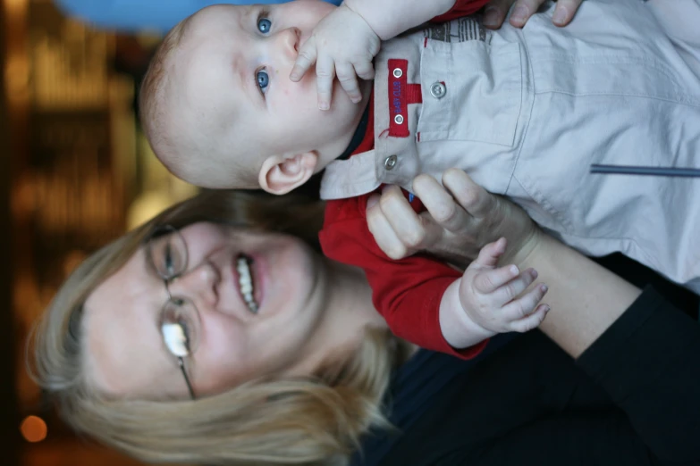 a smiling woman holding a baby in her arms