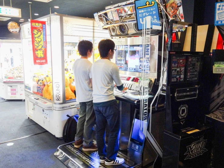 a boy and girl standing in front of an arcade machine