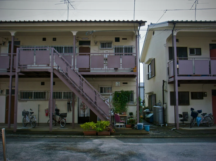 a pink stairway leads to two very tall buildings