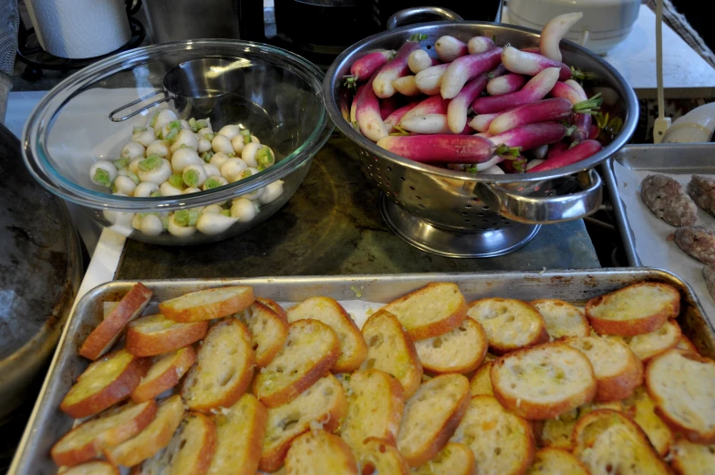 some silver pans are filled with different foods