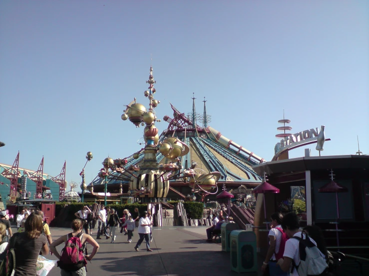 a colorful carnival entrance with many people walking