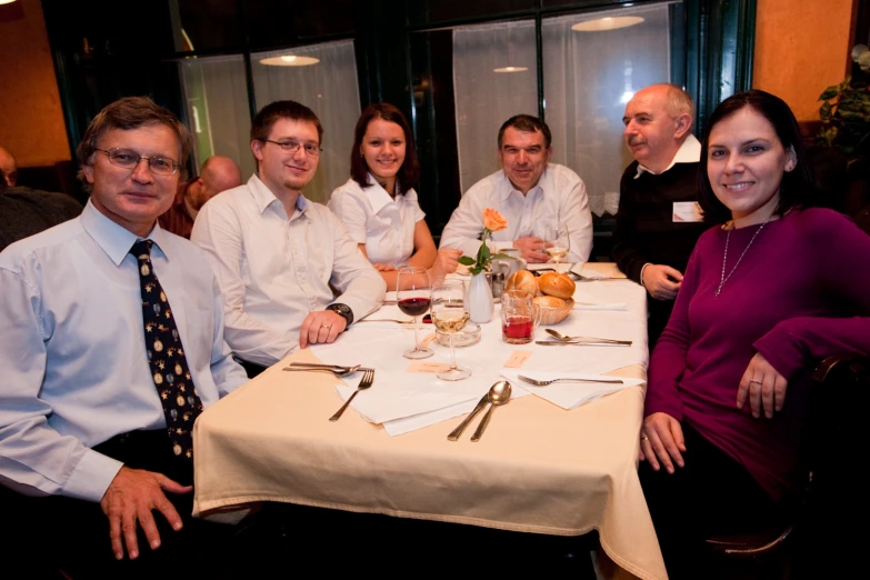 a group of people sitting around a table eating food and drinking