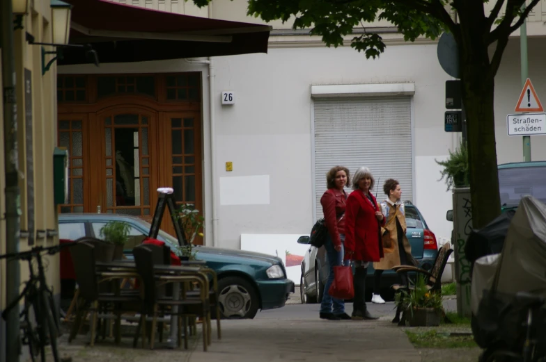 three women are walking down the street in their red jackets