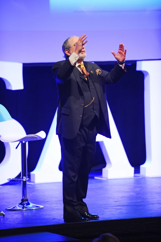 a man is speaking on stage at a convention