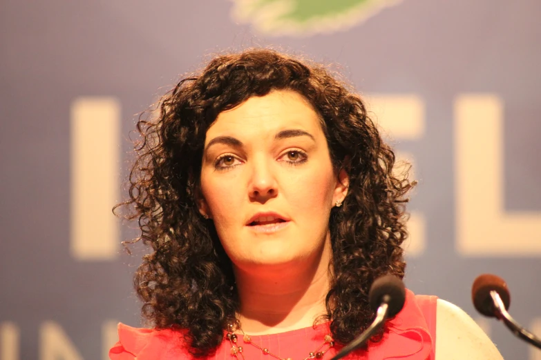 a woman at a podium with a microphone behind her