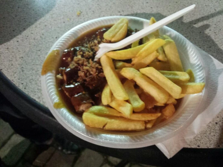 a plate of food with pickles, fries and chili