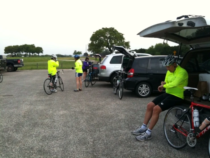 three cyclists and a bicyclist prepare to get in their car