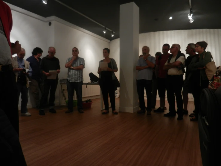 a group of people standing around in the living room