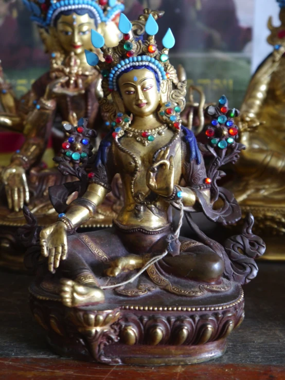 a statue on a wood table is painted gold