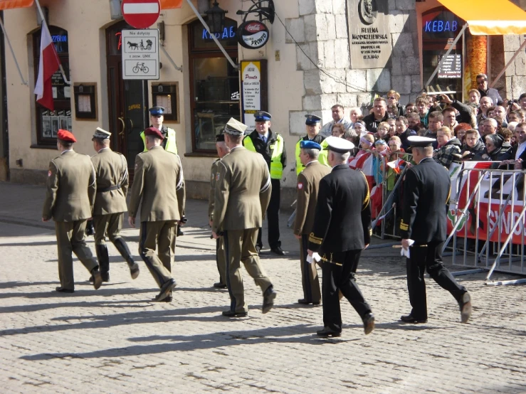 a group of men in dress clothes walking down the street