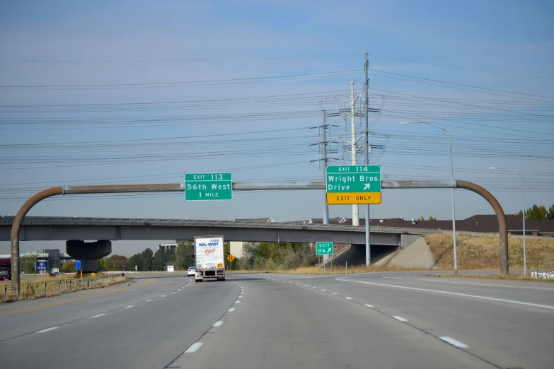 a long highway with street signs that point in different directions