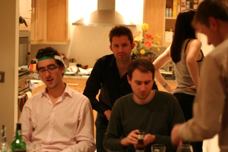 four young people are talking in a kitchen