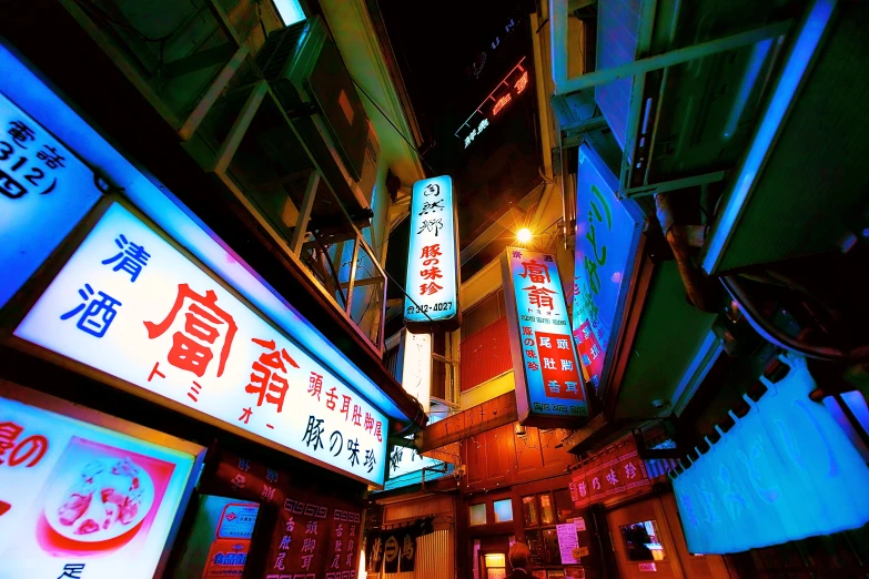 an alley in tokyo at night with lighted signs