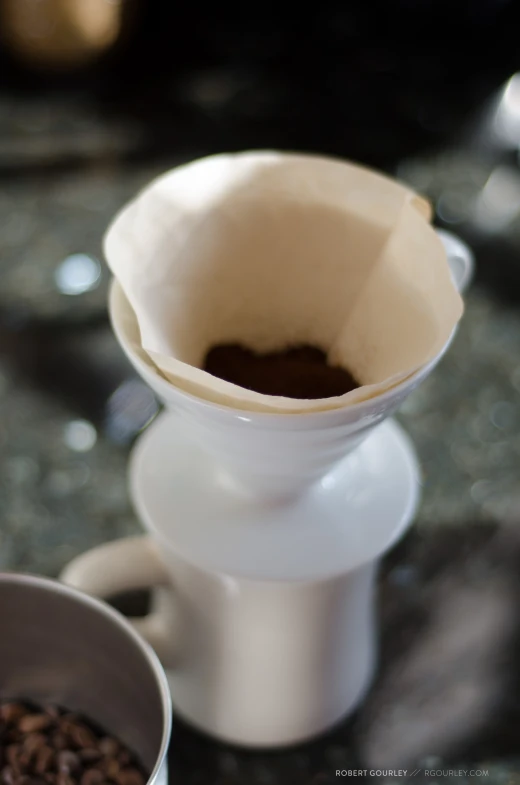 there is a white pouro pot and coffee beans