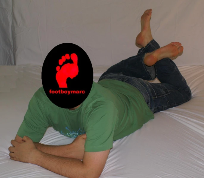 there is a man laying on a bed with a frisbee behind him