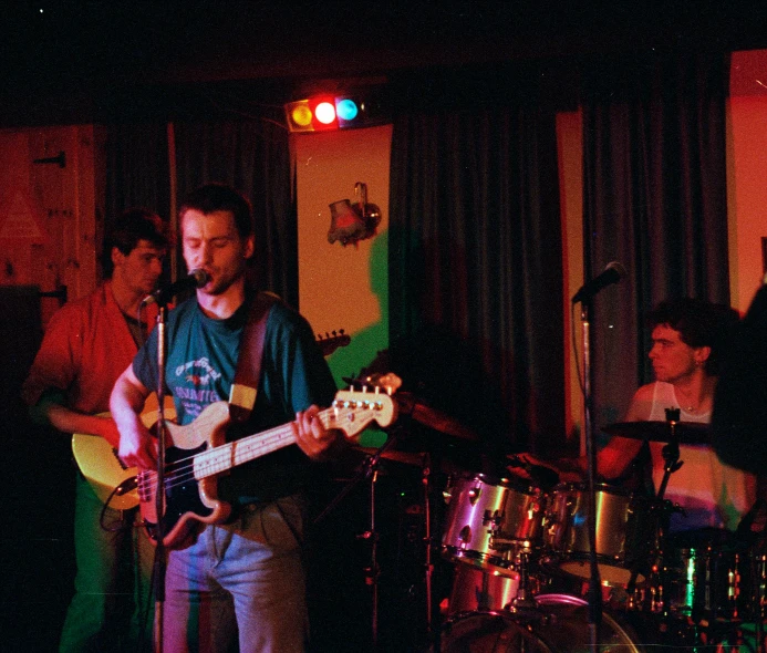 a man playing the guitar in front of other musicians