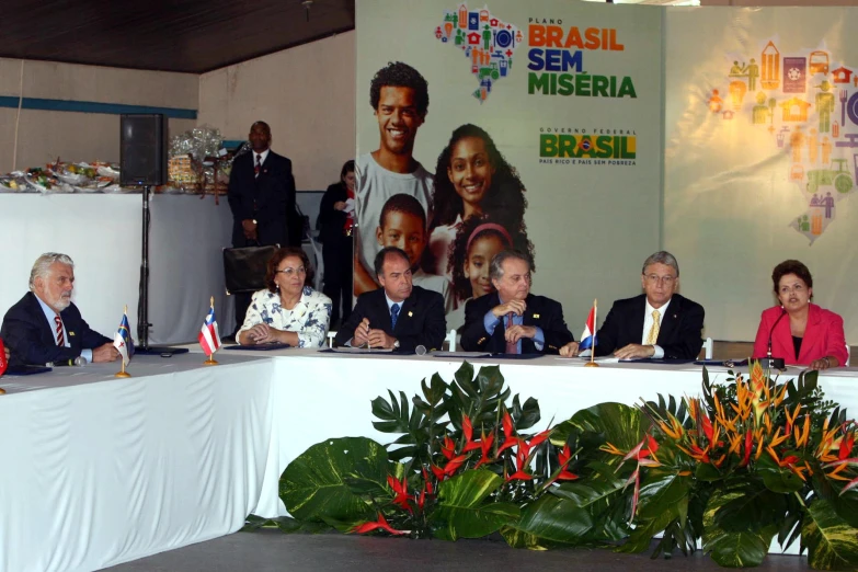 people sitting at a table with signs in front of them