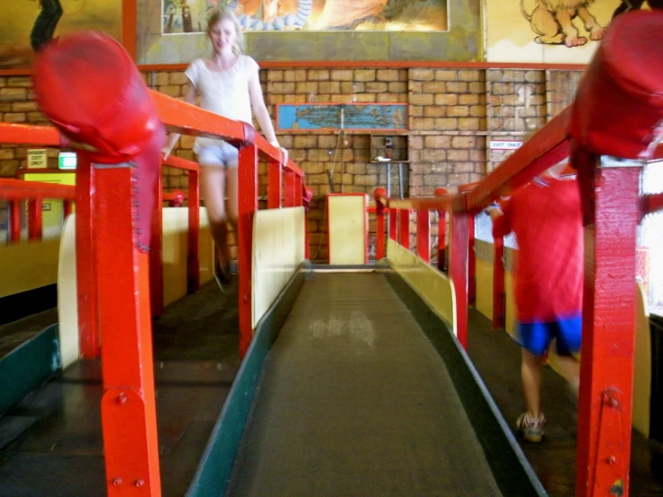 a woman walking up to the top of a wooden roller coaster