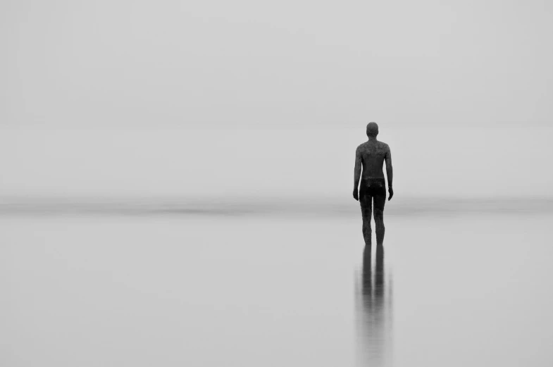 a man standing on top of a long sandy beach