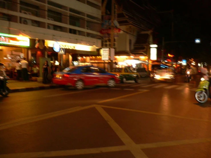 several cars at an intersection in a busy city