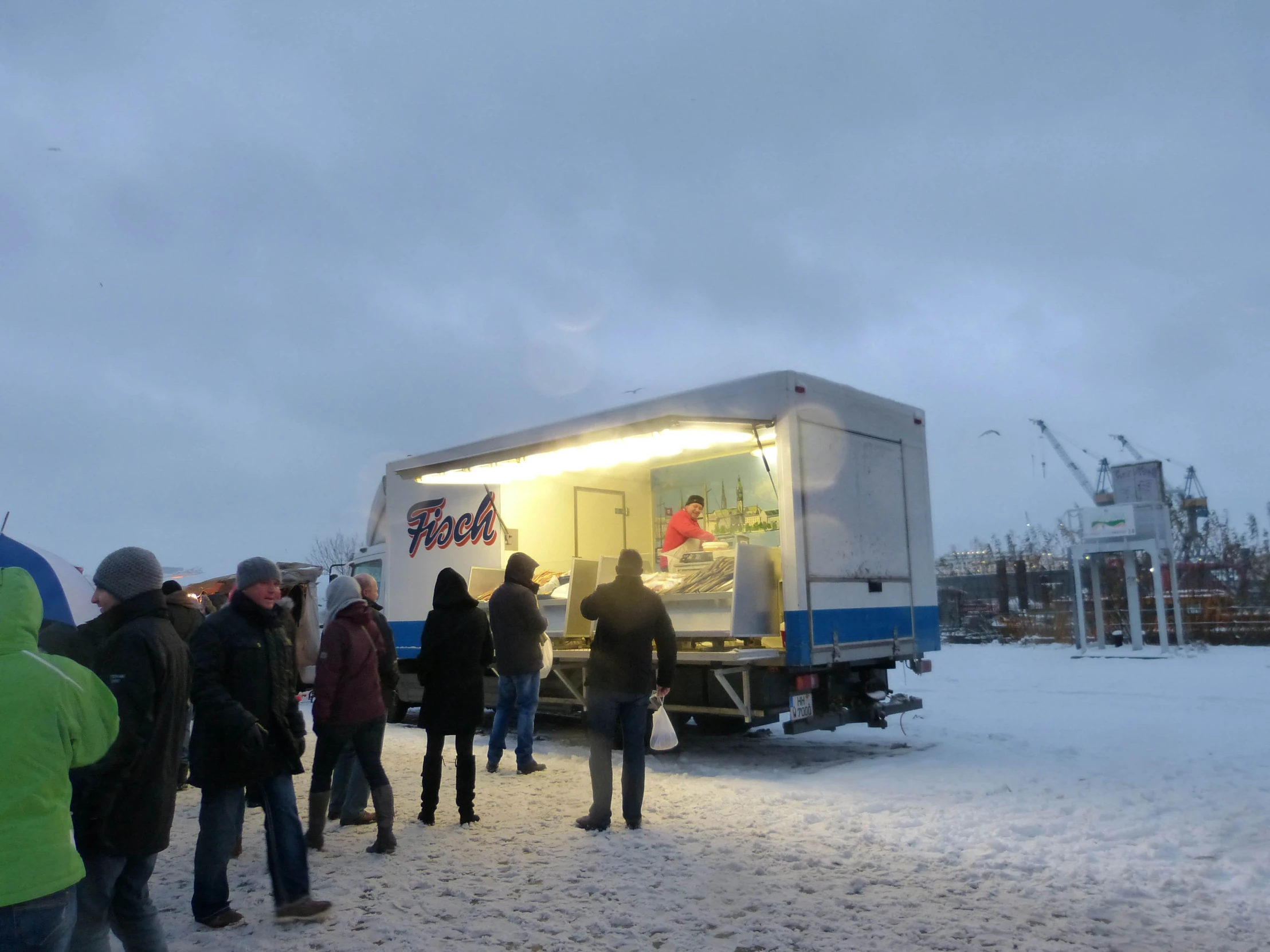 a group of people are gathered outside of a food truck