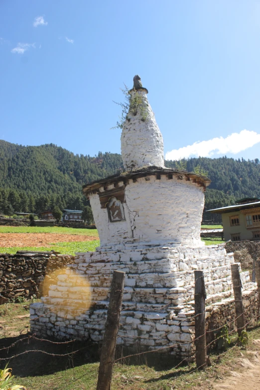 a stone pillar sitting in the middle of a grass field