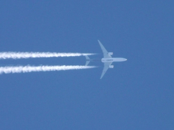 an airplane is flying through the air leaving contrails