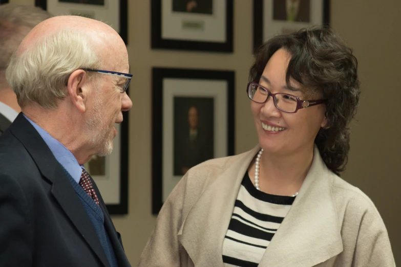 an older man smiling next to a woman