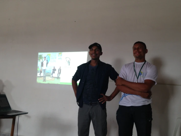 two men in a room with a projector on the wall