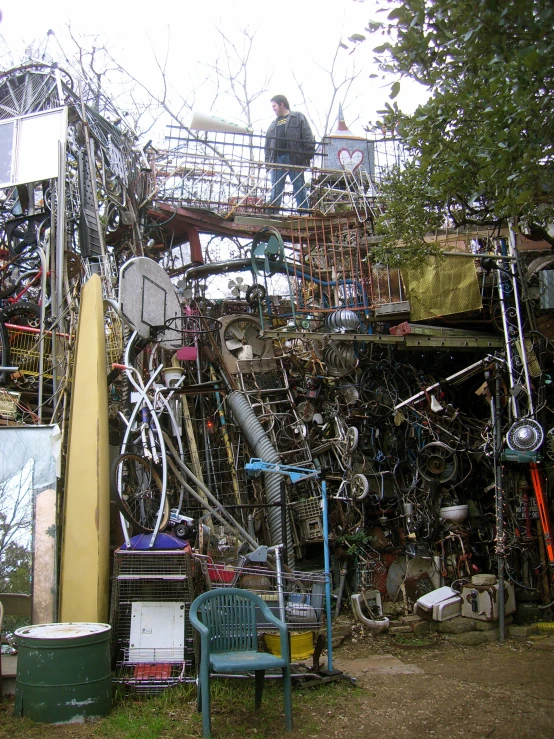 a man stands on the top of a pile of junk