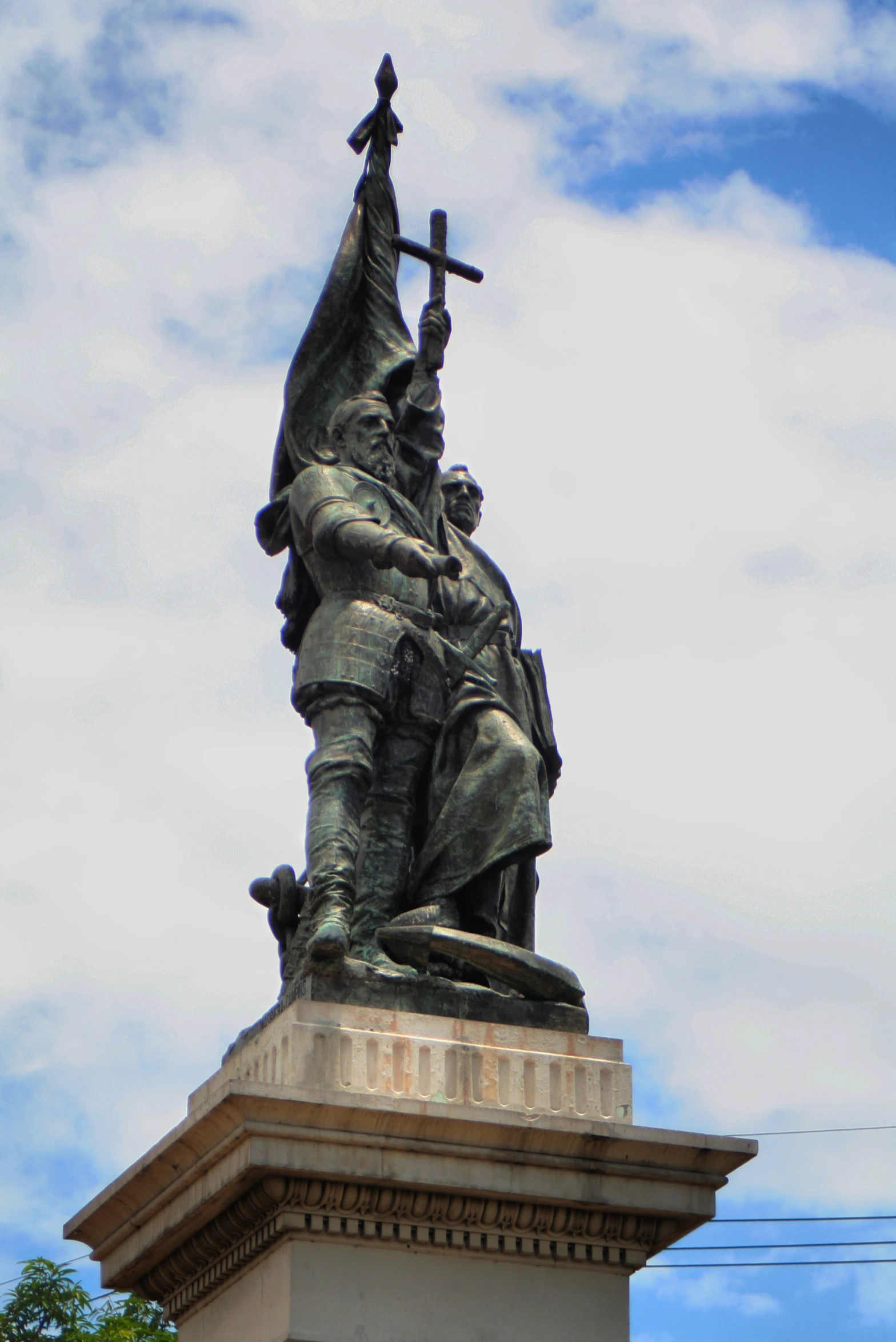 a statue is next to the building and blue sky