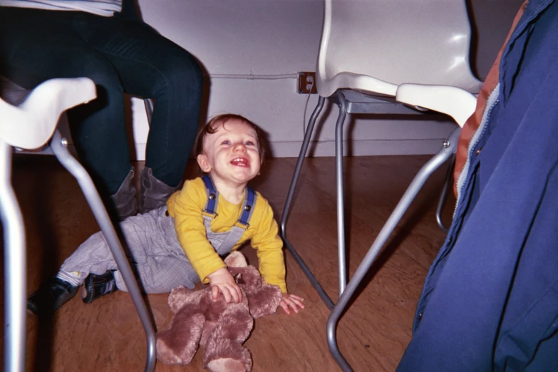 a  sitting in a chair holding a teddy bear