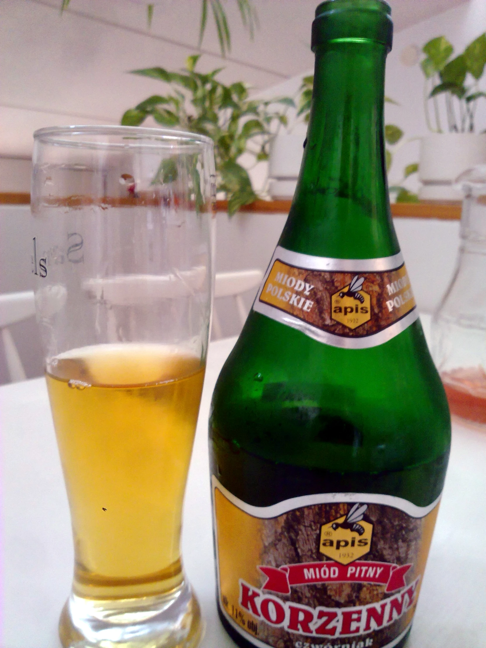 a close up of a bottle of beer next to a glass