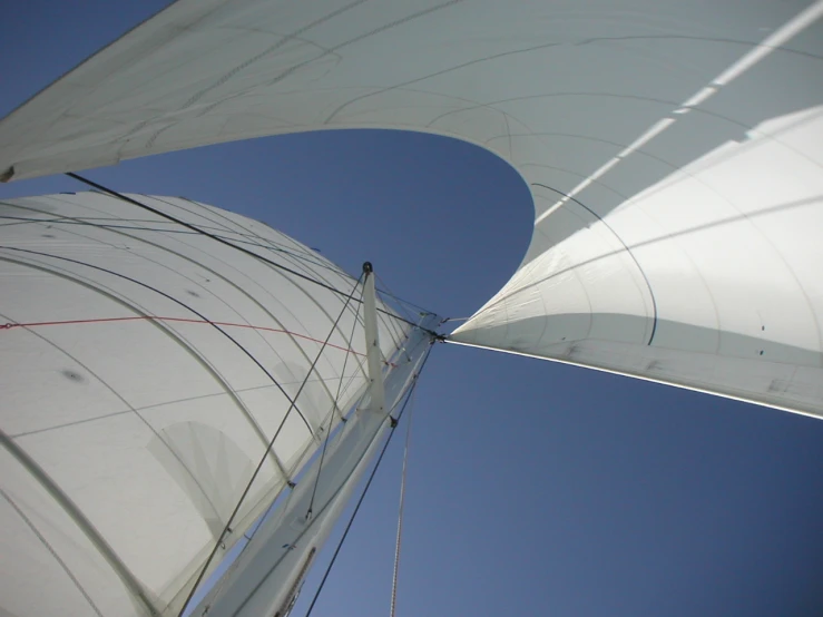 a white sail boat with red lines on its mast