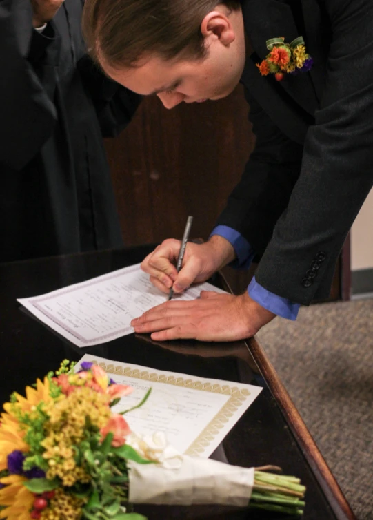 the man is signing into the document before his wedding ceremony