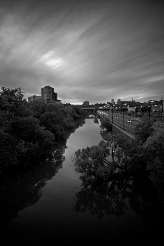 black and white image of a river with bridge