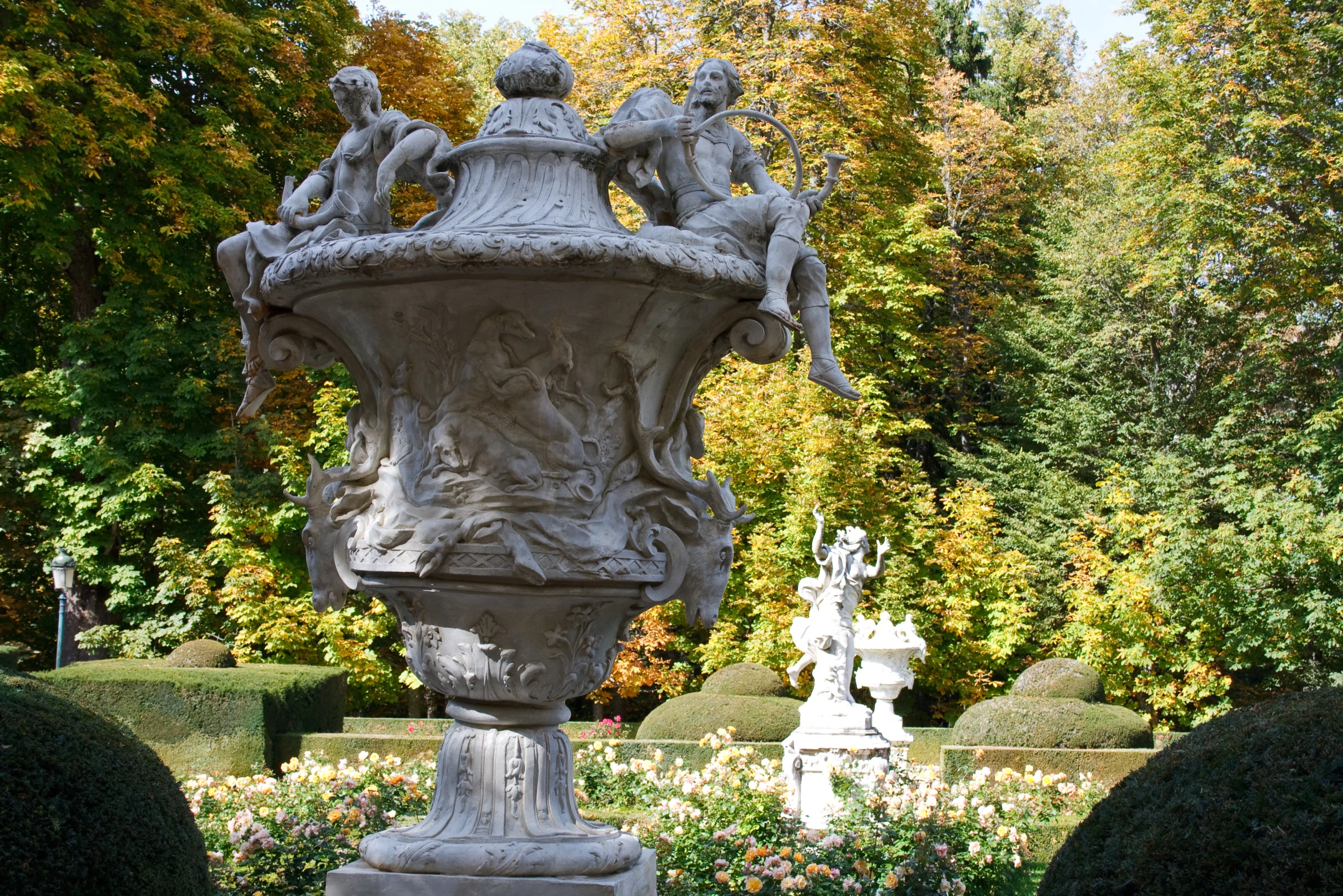 a very large vase sitting in the middle of a garden