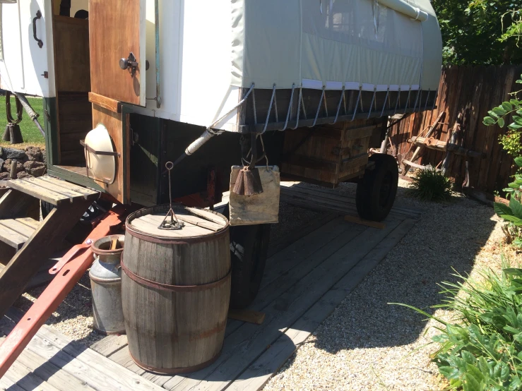 two large barrels are sitting beside a truck