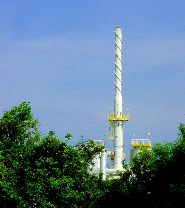 an industrial area with trees and tall smoke stacks