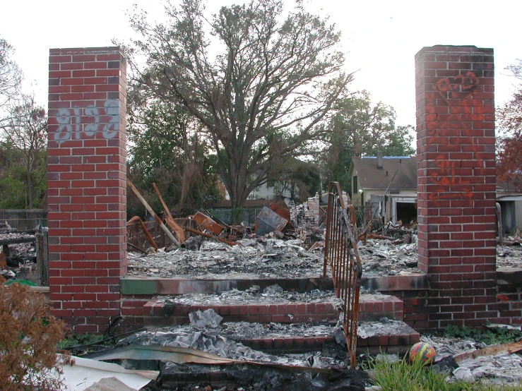 a destroyed house with trees and debris around it