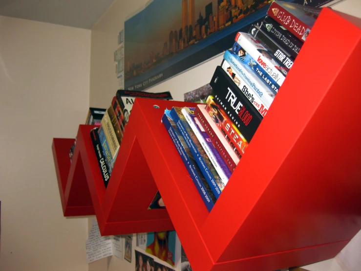 a row of red book stands in front of a wall