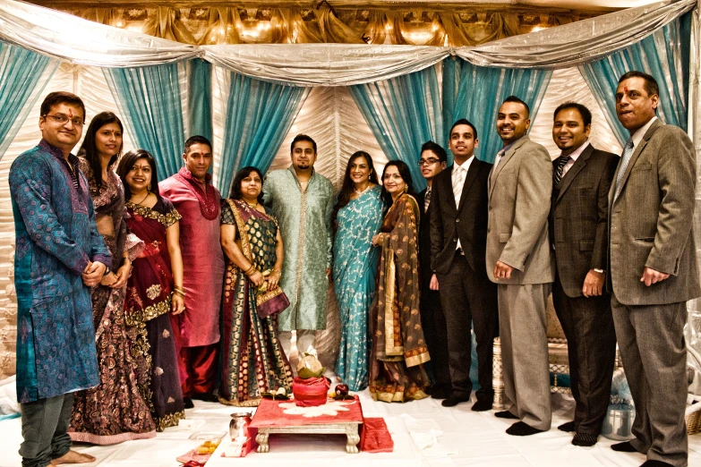 a large group of people standing in front of a cake