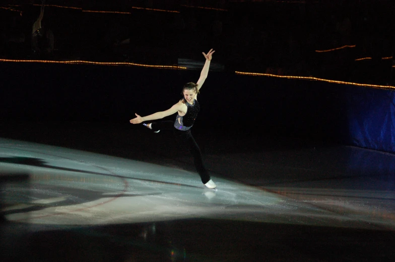 the man in black is performing on the ice